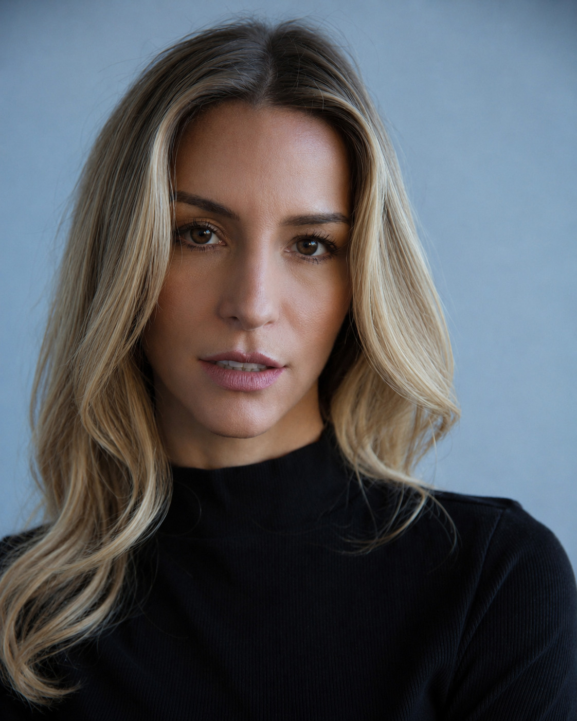 Belén Cusi in a black turtleneck against a blue background