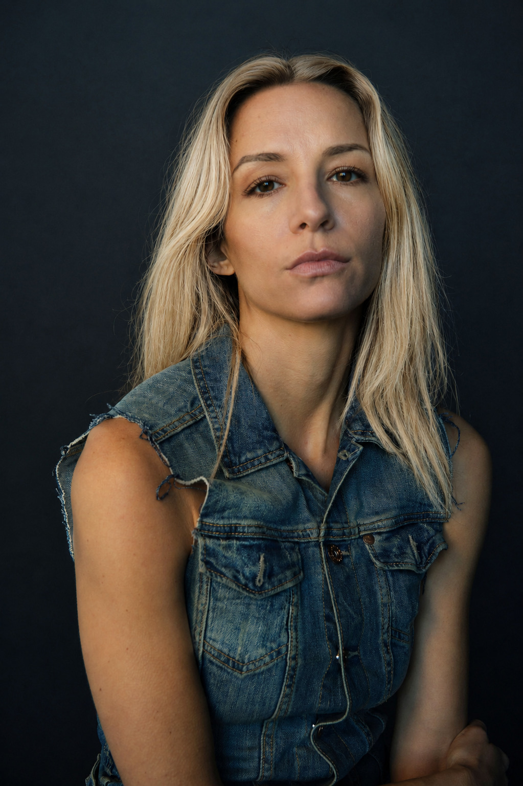 Belén Cusi in a denim vest against a dark background
